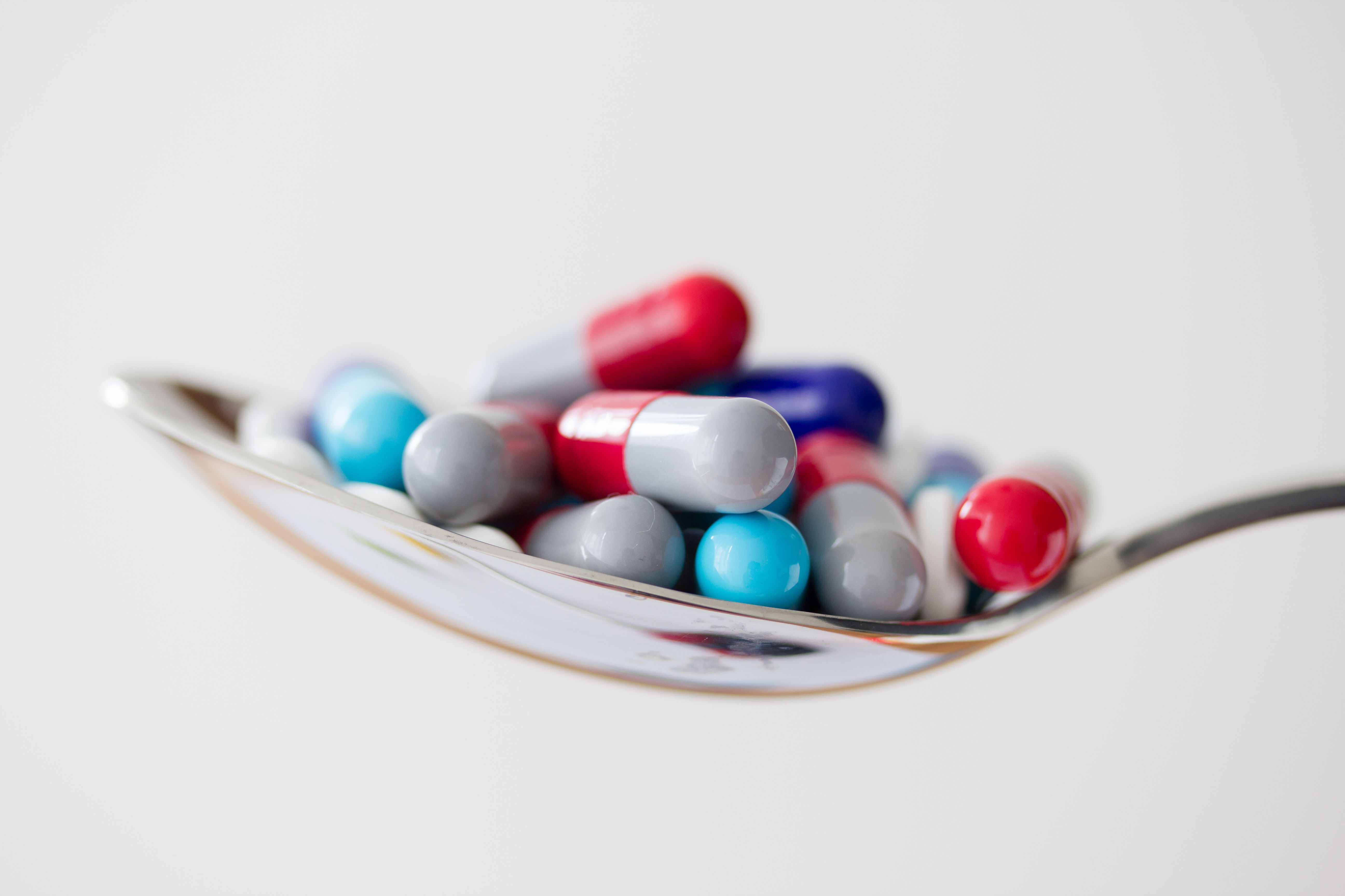 A spoon with multiple different pills on it