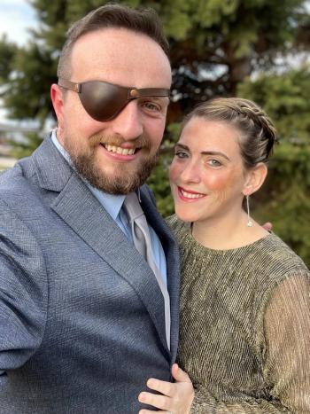 Phil Stewart wearing an eye patch, standing next to his wife and caregiver, Caitlyn Stewart