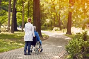 Woman pushing man in wheelchair. 