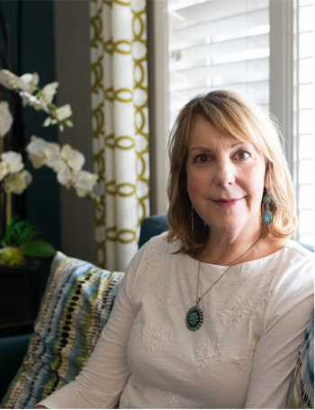 Myeloma survivor, Cindy Brown, sits on a couch and looks at the camera. | Photo credit: Jackie Ceja