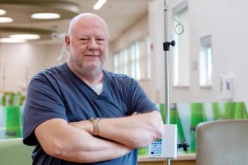 Anthony "Tony" Reynolds, RN, a nurse wearing blue scrubs, standing in front of an IV pole — Photo courtesy of Appalachian Regional Healthcare