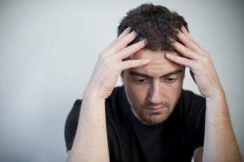 Man in black shirt holding his head