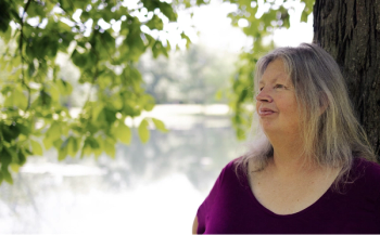 Image of a woman with shoulder-length hair, wearing a purple shirt.