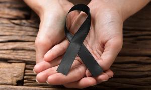 Image of a melanoma ribbon in a person's hands.
