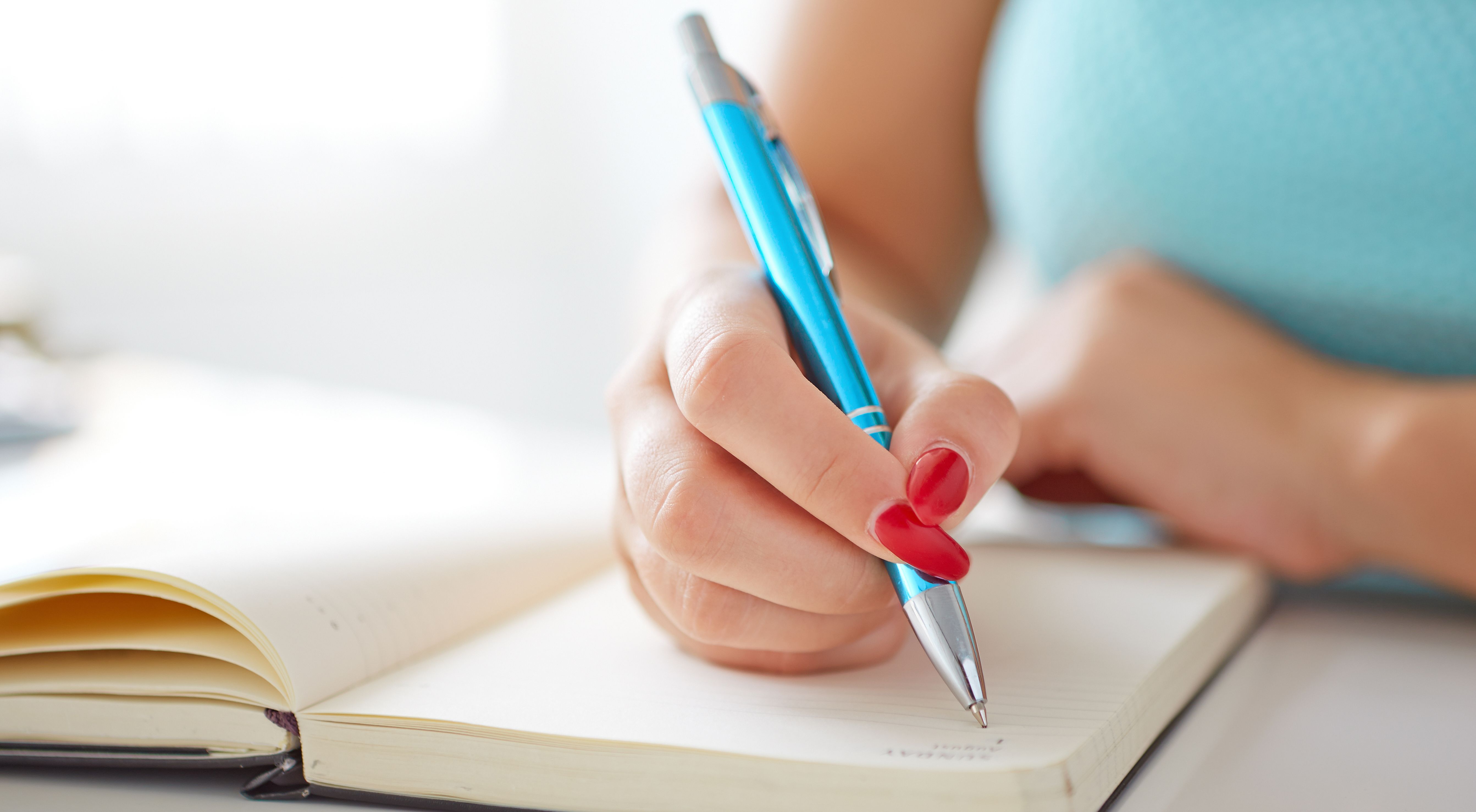 Image of woman writing with pen.