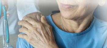 elderly woman holding the hand of an oncology nurse
