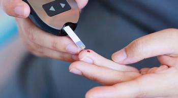 person pricking their finger and using a glucose monitor