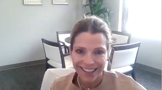 Image of a woman with tied back hair, wearing pearl earrings.