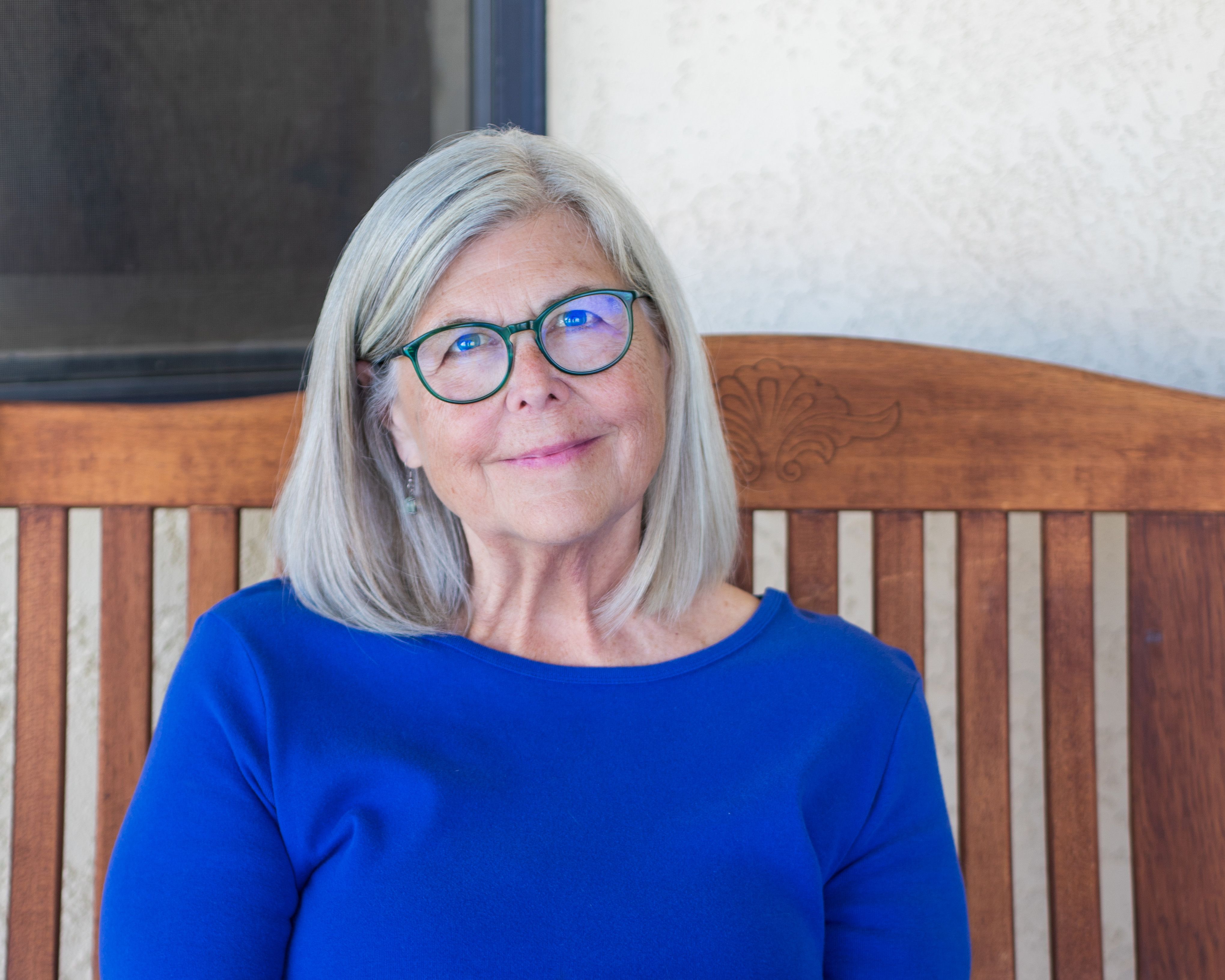 Image of a woman with shoulder-length hair and round glasses.