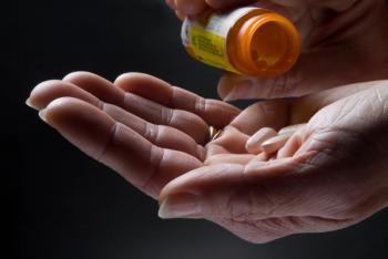 Image of a person pouring pills into their hand. 