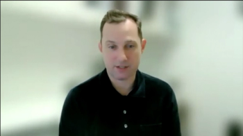 Image of a man wearing a black button-up shirt. 