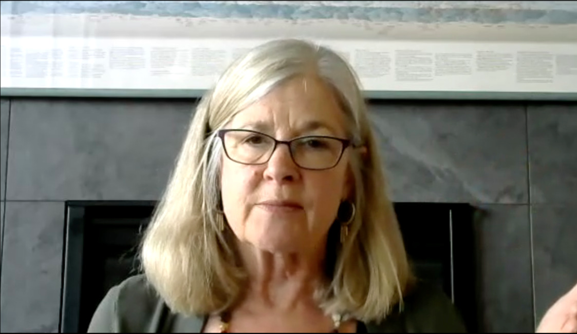 Image of a woman with light shoulder-length hair, wearing rectangular glasses.