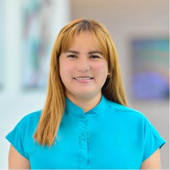 Myra Escudero, M.S.N., RN, an oncology nurse with blonde hair, wearing a bright blue shirt, smiling at the camera | Photos by Agne Sopyte