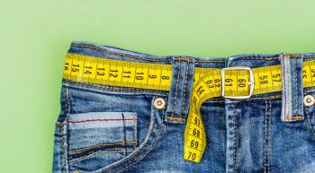 image of jeans with a measuring tape threaded through the background