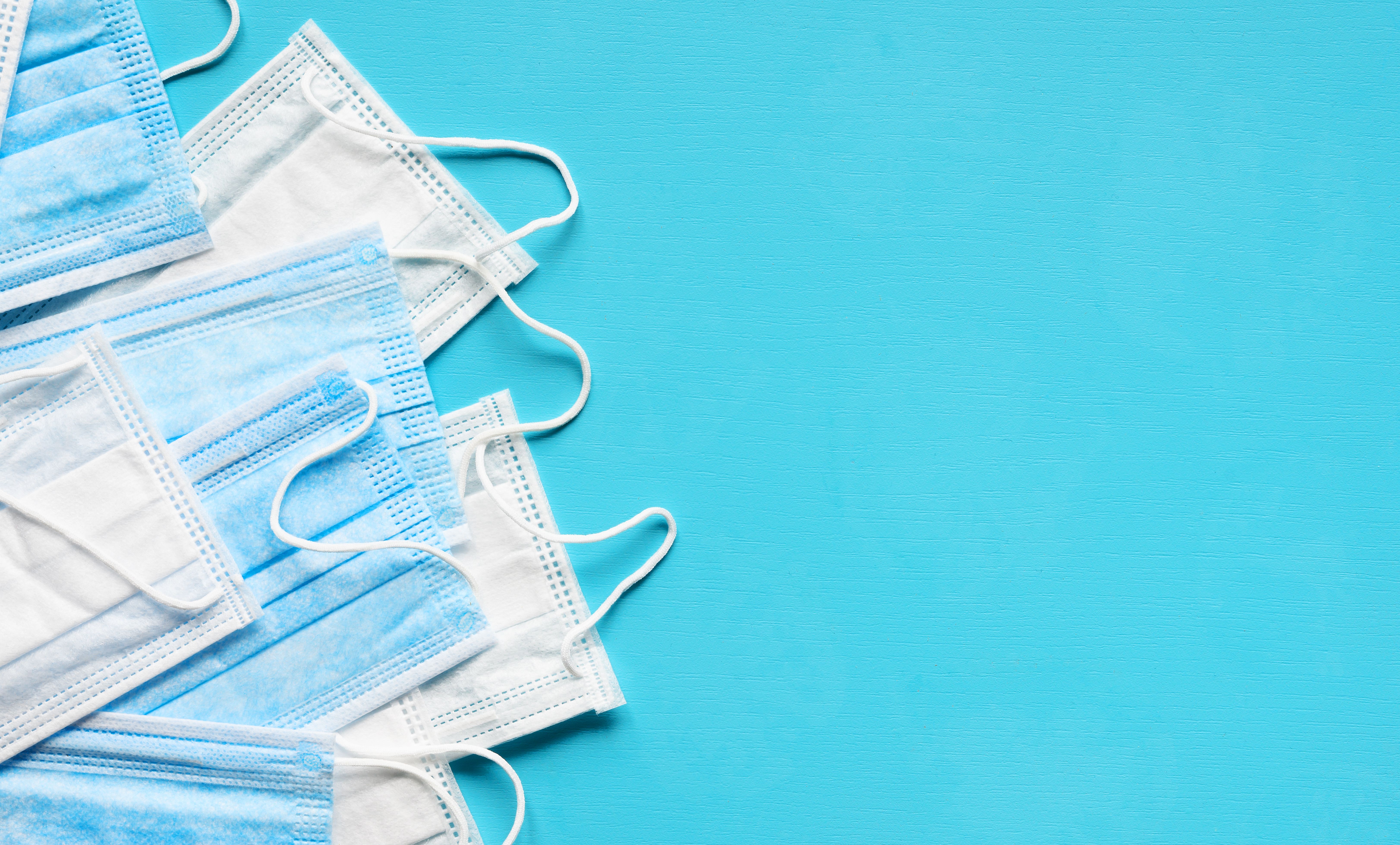 Medical face masks on blue background. Protection against coronavirus, flu and other airborne infection. Copy space | Image credit: © - Soho A studio - © stock.adobe.com
