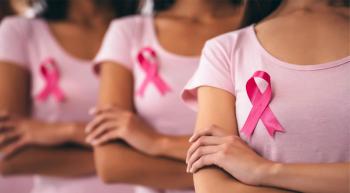 Three women stand with their arms crossed, wearing pink T-shirts and pink ribbons
