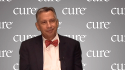 Image of a man wearing a suit with a red bowtie.