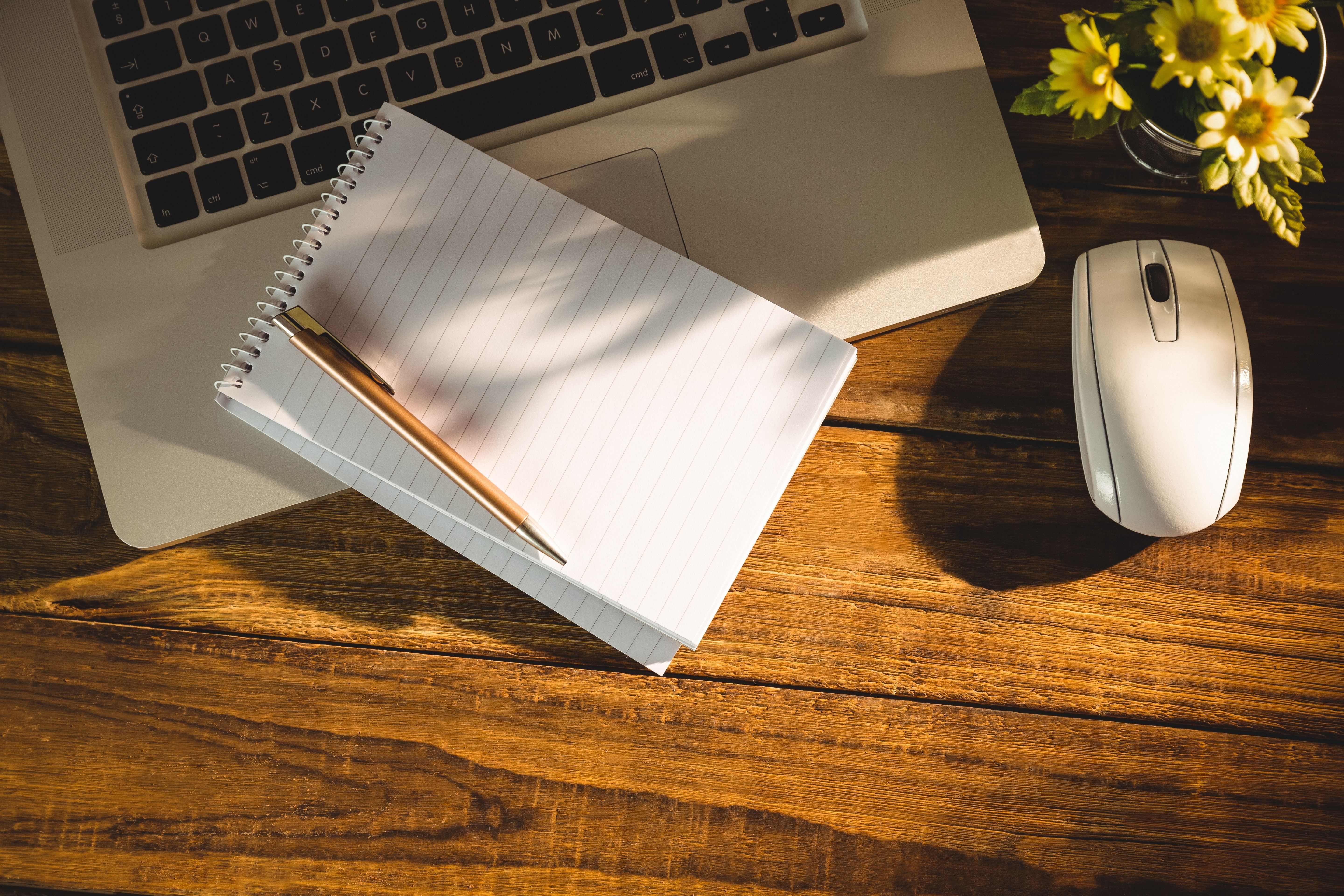 letter and pencil on top of a laptop