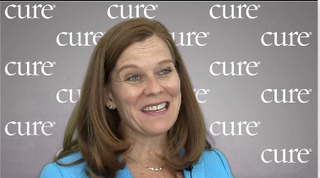 Image of a woman with layered hair, wearing a bright blue cardigan.