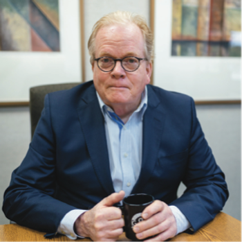 lung cancer survivor David Sturges wearing a blue sports coat and holding a cup of coffee