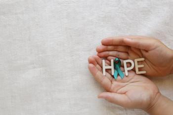 Image of a person holding the word "hope" with a teal ribbon for ovarian cancer.
