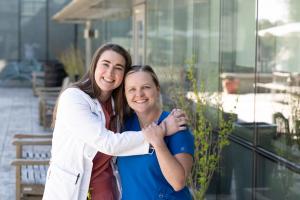 Georgia Smith, M.S.N., FNP-BC smiling at the camera, hugging Georgia Smith, M.S.N., FNP-BC and Emily Bryant, B.S.N., RN, CMSRN | Photo by Catherine Davis 