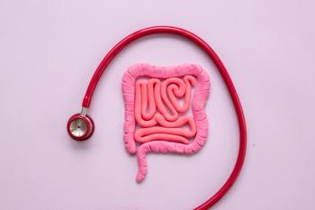 Image of a cartoon colon with a stethoscope around it on a pink background. 