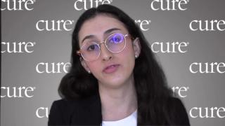Image of a woman with dark brown hair and round glasses wearing pearl earrings.