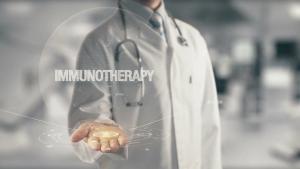 doctor in white coat holding out hand with the word "immunotherapy" floating in front of it