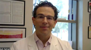 Image of a doctor with dark curly hair and rectangular glasses.