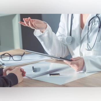 Photo of a doctor and patient speaking over a desk