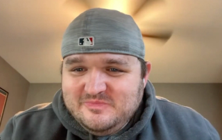 Image of man wearing baseball cap backwards.