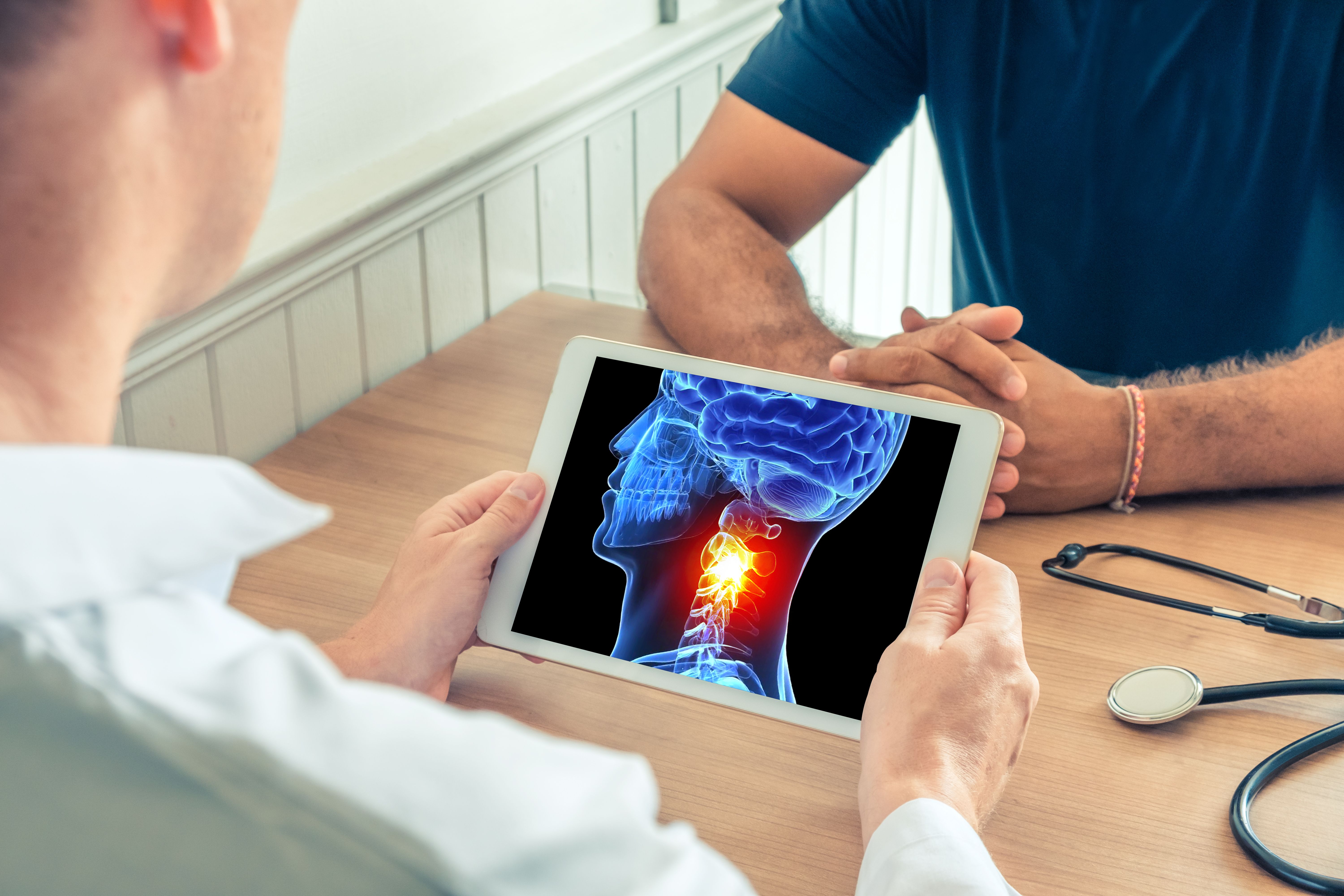 Image of a doctor reviewing an image of head and neck cancer with a patient.