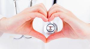 Image of a doctor making a heart with their hands. 
