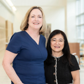 Image of two women standing next to each other, smiling. 