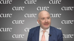 Image of a man with gray facial hair and a navy blue suit with a light orange tie. Image of a man with gray facial hair and a navy blue suit with a light orange tie.