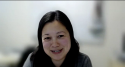 Image of a woman with black hair, half moon-shaped eyes, rosy cheeks and a toothy smile. 