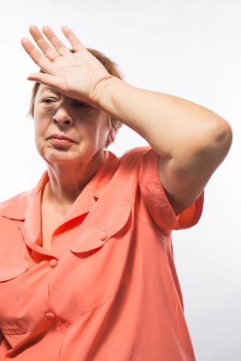 woman in orange shirt experiencing a hot flash