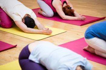 people doing child's pose in a yoga class