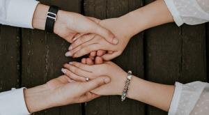 Image of a patient with a caregiver, holding hands.