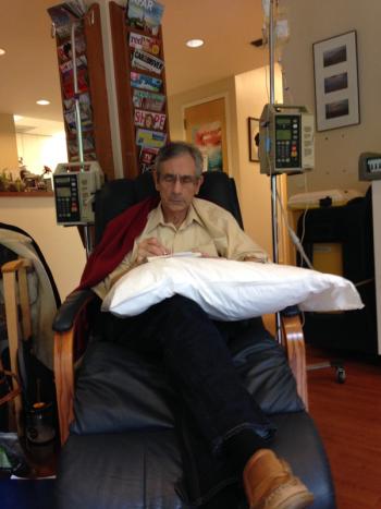 Image of a man sitting in a chair writing.