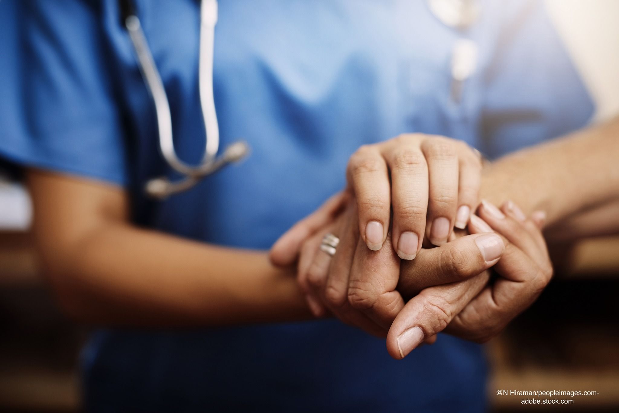 Image of doctor and patient holding hands.