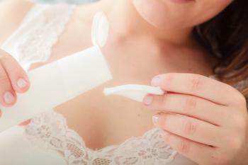 person putting skincare product on cotton pad