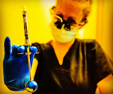 Dental hygienist holding a syringe