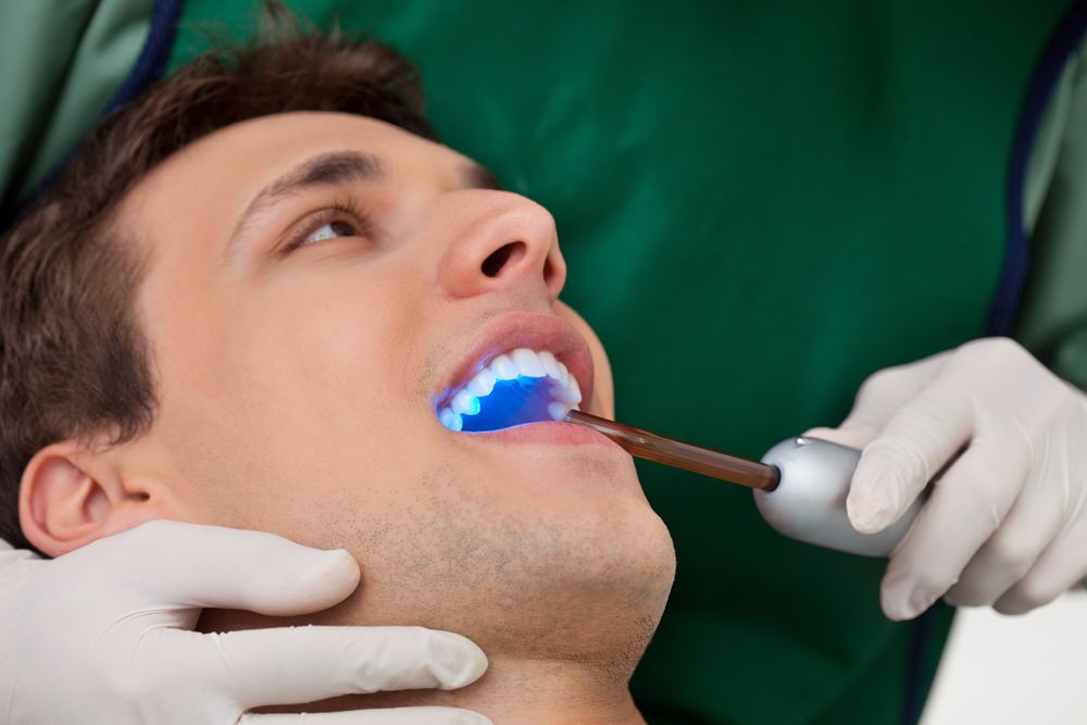 Dentist holding a curing light.