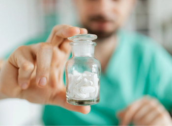 pharmacist holds up bottle of medications