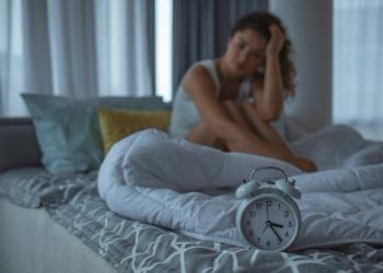woman awake with alarm clock