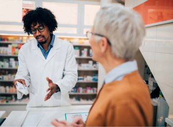 Pharmacist at the counter counsels a patient