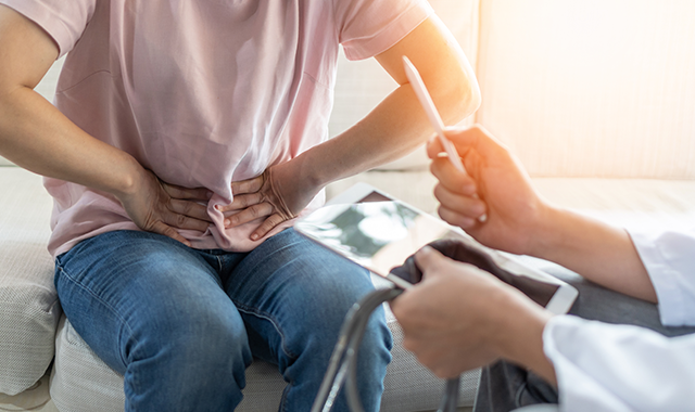 doctor counseling patient grabbing abdomen