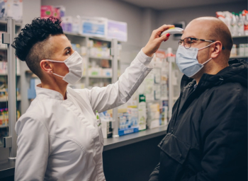 pharmacist taking temperature of patient
